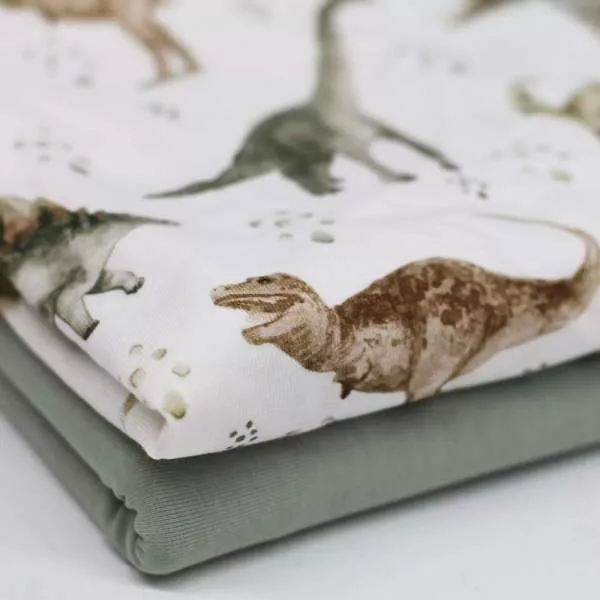 Baumwolljersey Stoff mit Dinosaurier Motiv in Naturtönen auf ecru Hintergrund – Kinderstoff als Meterware zum Nähen von Baby- und Kinderkleidung